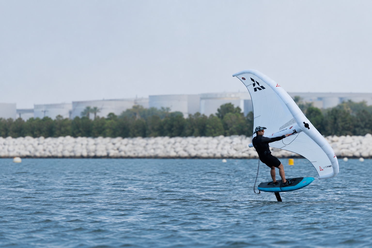 Wingfoil rider flying above turquoise water